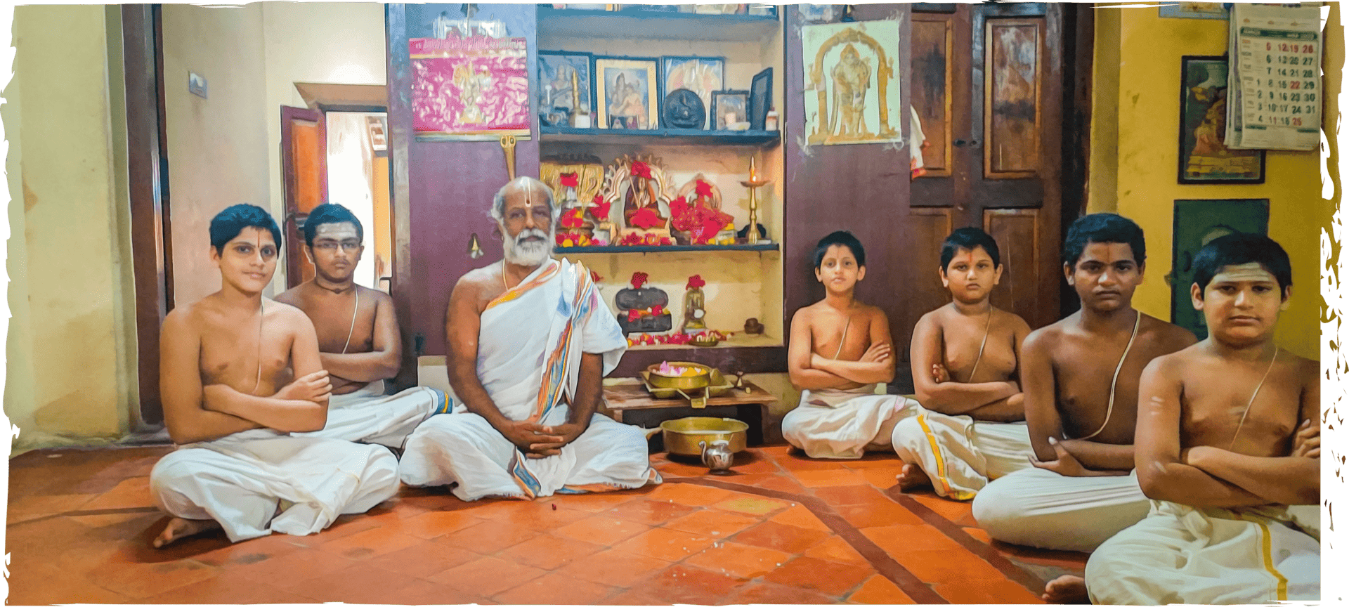 Image of Vedic students with their guru in a Pooja room.